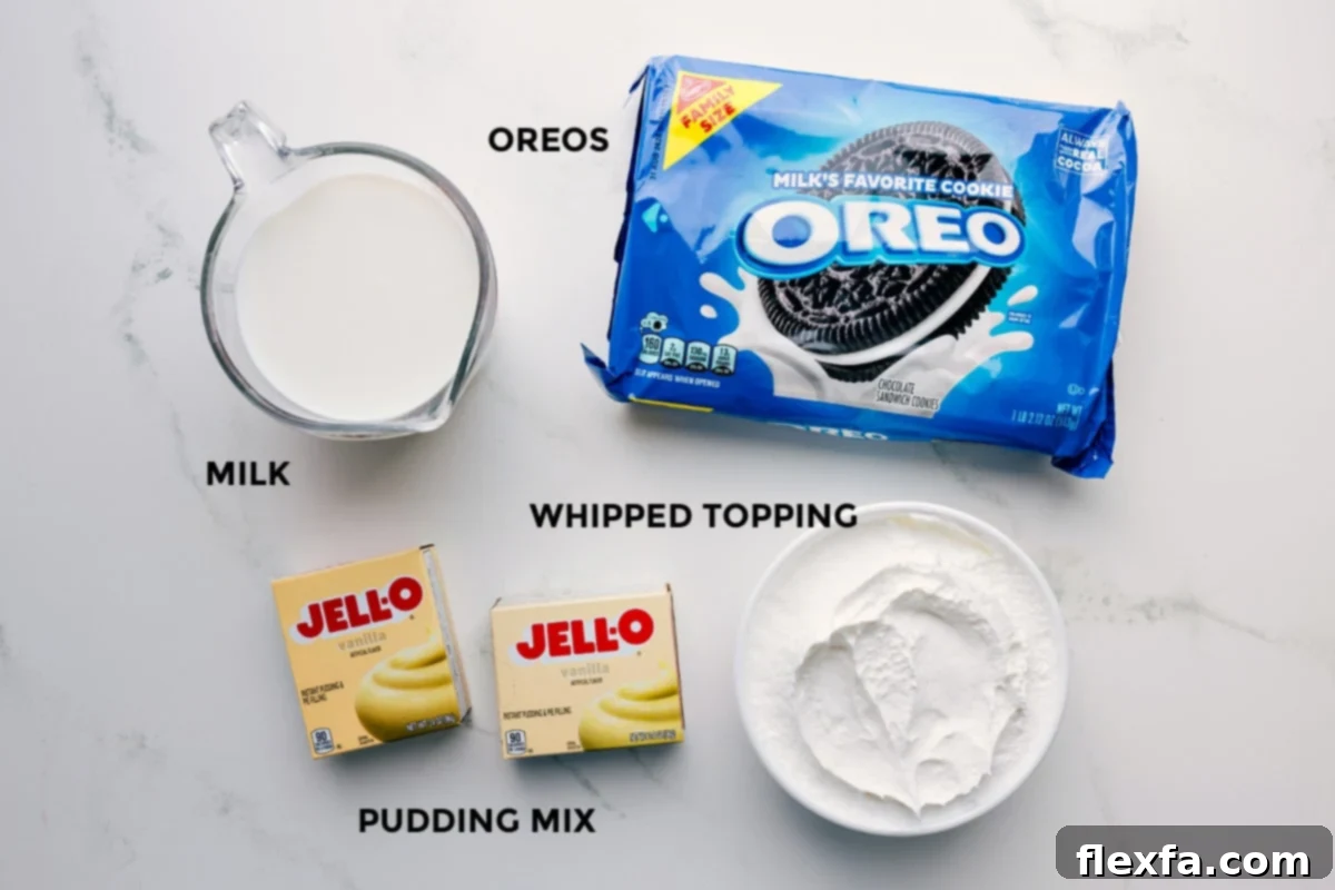 All the necessary ingredients prepped and laid out for easy assembly, including a stack of Oreo cookies, a glass of milk, a tub of whipped topping, and a box of instant pudding mix.