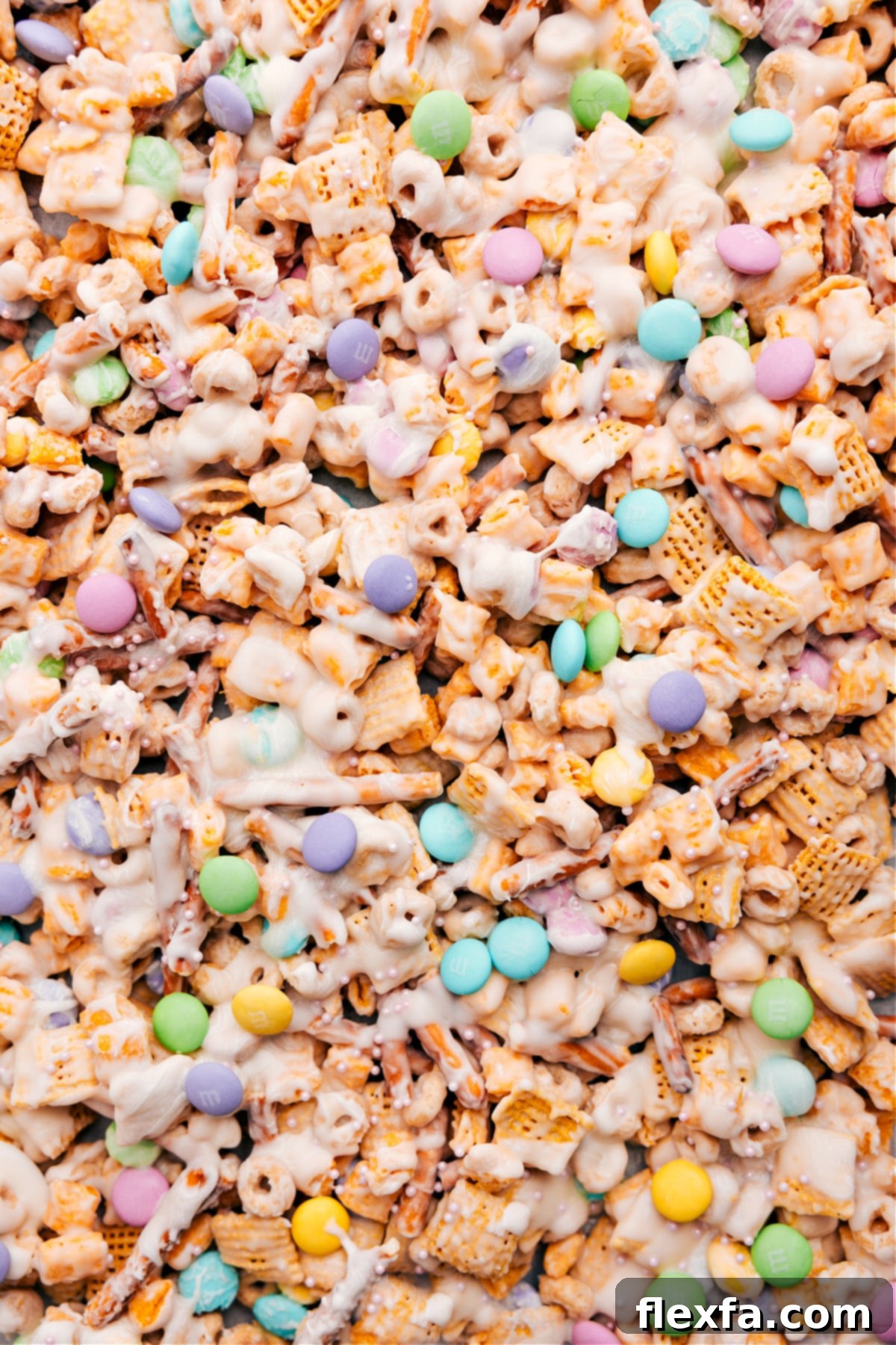 The Best Easy Bunny Bait Recipe for Easter Bunny Bait recipe spread on a baking sheet, topped with colorful sprinkles and spring M&M's, ready to be broken into pieces.