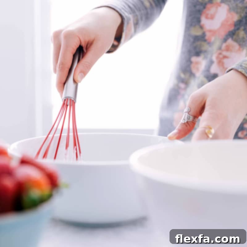 Wet ingredients being whisked together in a bowl, a crucial step for achieving the perfect consistency for the best waffle recipe.