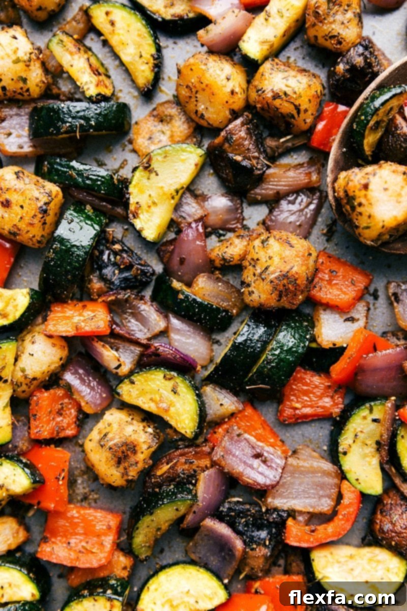 Baked Gnocchi with vegetables, still on the sheet pan, fresh out of the oven, garnished with fresh herbs and parmesan.