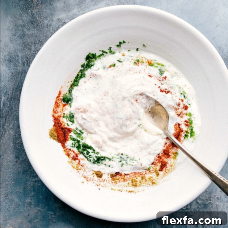 Elote cream sauce being thoroughly mixed with various spices in a bowl.
