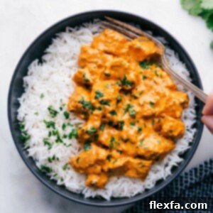 A beautiful bowl of Chicken Tikka Masala, showcasing tender marinated chicken pieces submerged in a rich, creamy, and vibrantly spiced tomato sauce, ready to be served.
