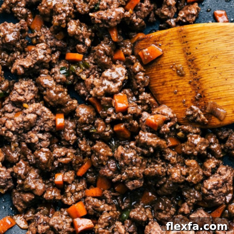 Savory Beef Lettuce Cups 3 Cooked ground beef with carrots used in Asian-style beef lettuce wraps, ready to be wrapped in lettuce leaves, bursting with flavor.