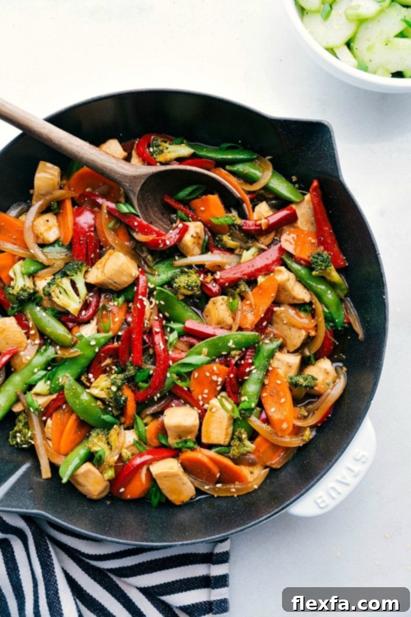 Chicken stir fry in a skillet, brimming with vegetables and rich flavors, prepared for serving.