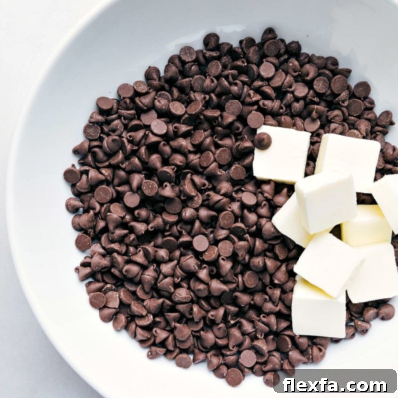 Chocolate chips and cubed butter being carefully placed into a mixing bowl, ready to be melted for the rich brownie batter.