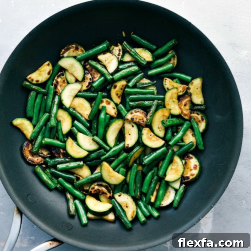 Zucchini and green beans cooked to perfection in a saucepan, tender and flavorful.