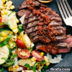 Simple & Delicious Flat Iron Steak 3 Sliced grilled flat iron steaks, generously topped with sun-dried tomato sauce, served with a side of grilled corn and zucchini salad, creating a hearty and delicious meal.