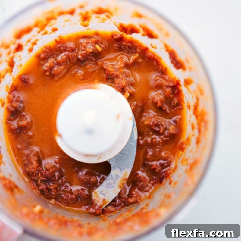 Blending Sun-Dried Tomato Sauce in Food Processor Blending the sun-dried tomato sauce in a food processor, capturing the vibrant ingredients coming together to create a rich, flavorful sauce.