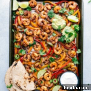 Freshly baked sheet pan shrimp fajitas, vibrant with colorful peppers and onions, ready to be assembled into a delicious meal.