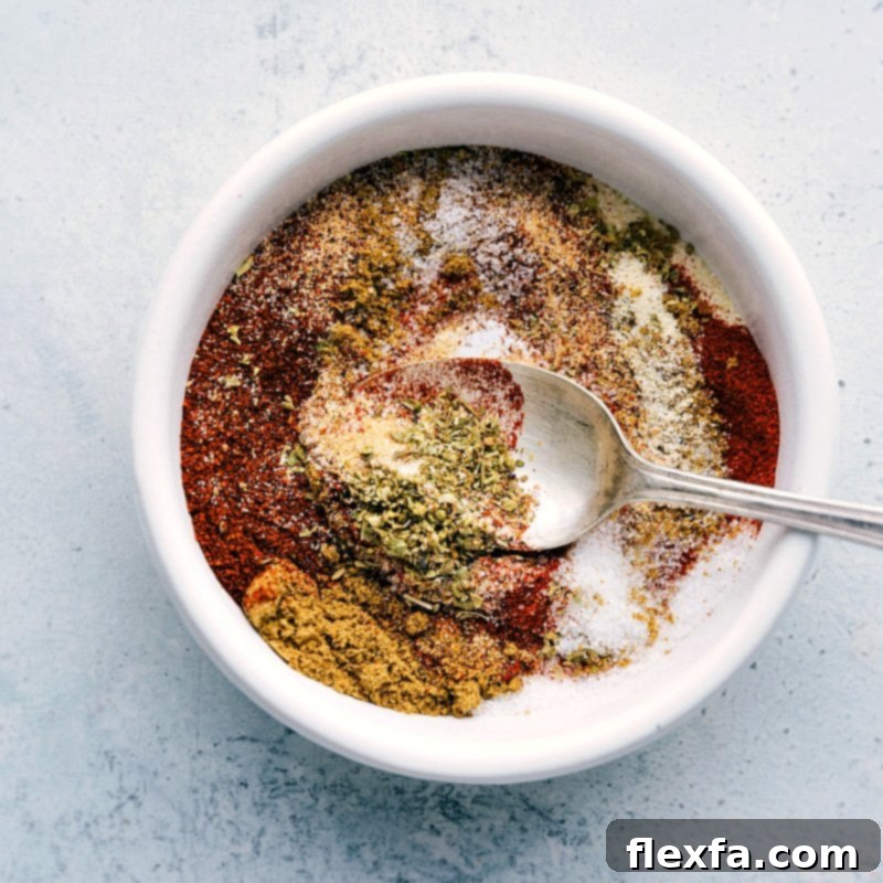A bowl filled with a homemade fajita seasoning blend, including chili powder, ground cumin, onion powder, garlic powder, paprika, dried oregano, salt, and pepper.