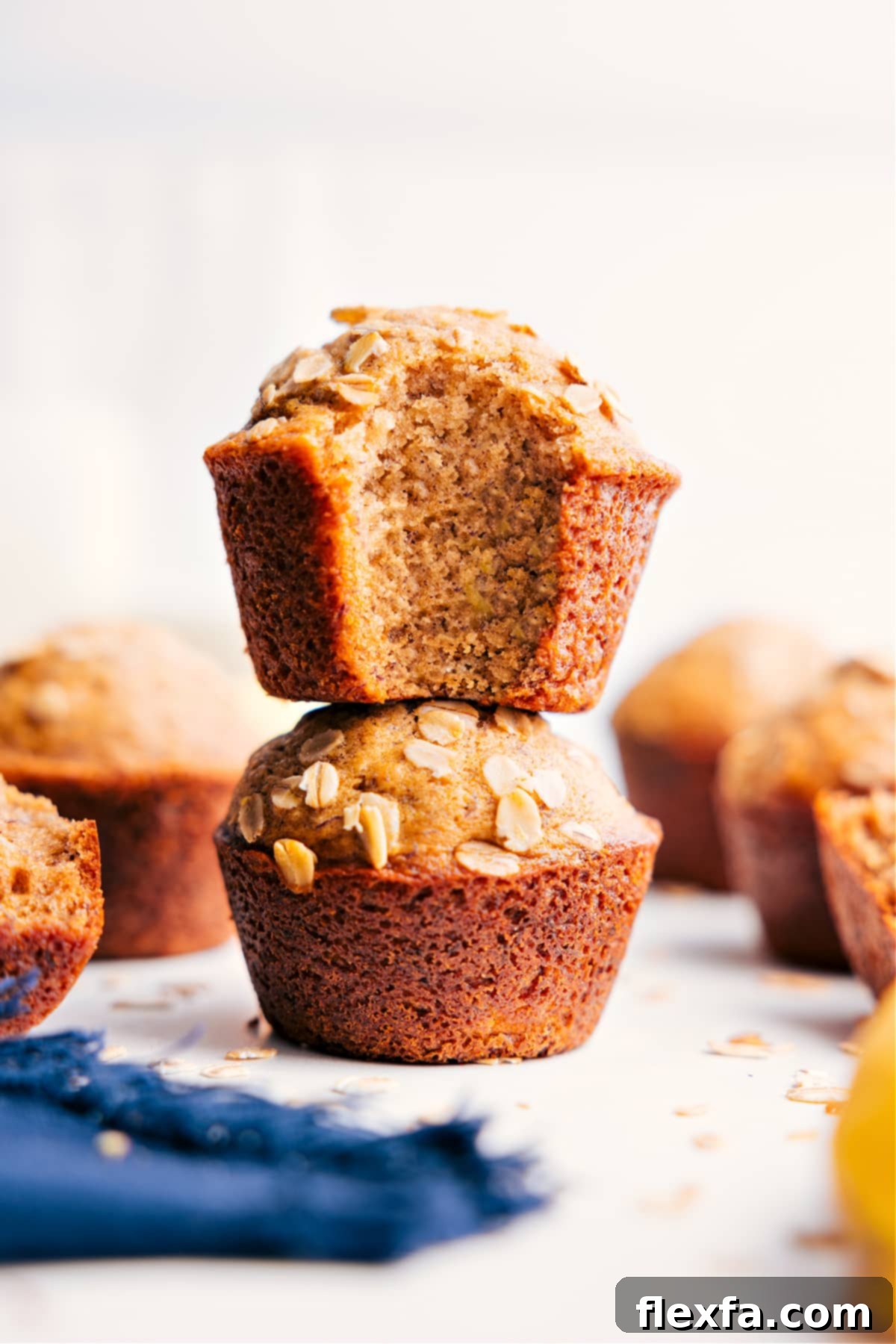 The Best Healthy Banana Muffins Recipe: A Wholesome Treat Stacked Healthy Banana Muffins, golden brown and moist, with the top muffin having a bite taken out, revealing its soft, delicious interior and specks of banana.