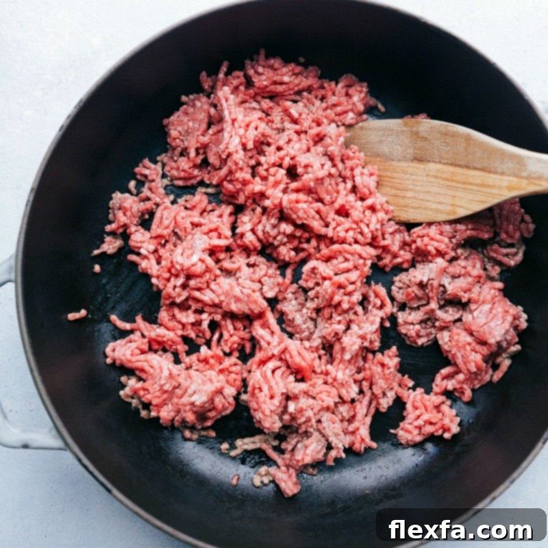 Ground beef being cooked on a skillet, a crucial step in this recipe.