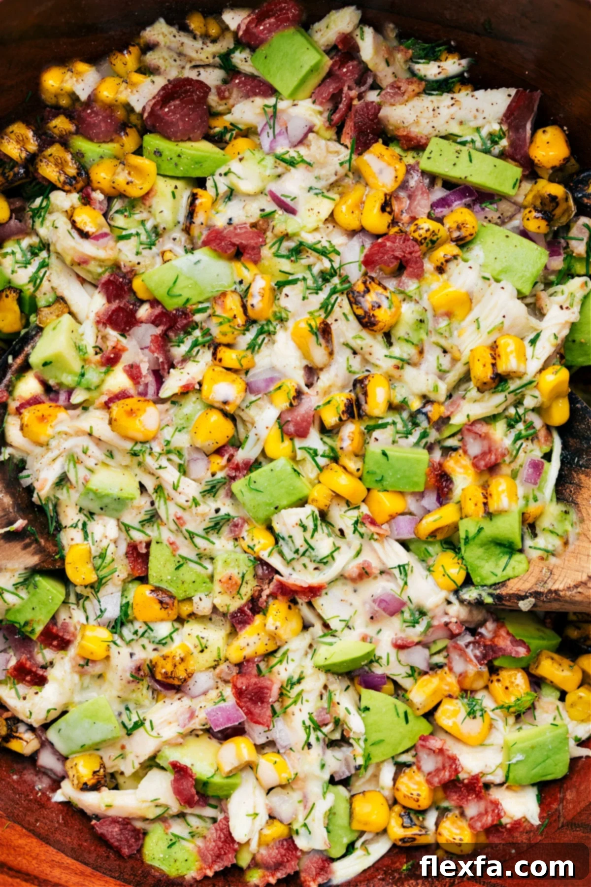 A bowl of vibrant Avocado Chicken Salad, perfectly dressed and tossed, showcasing fresh ingredients.