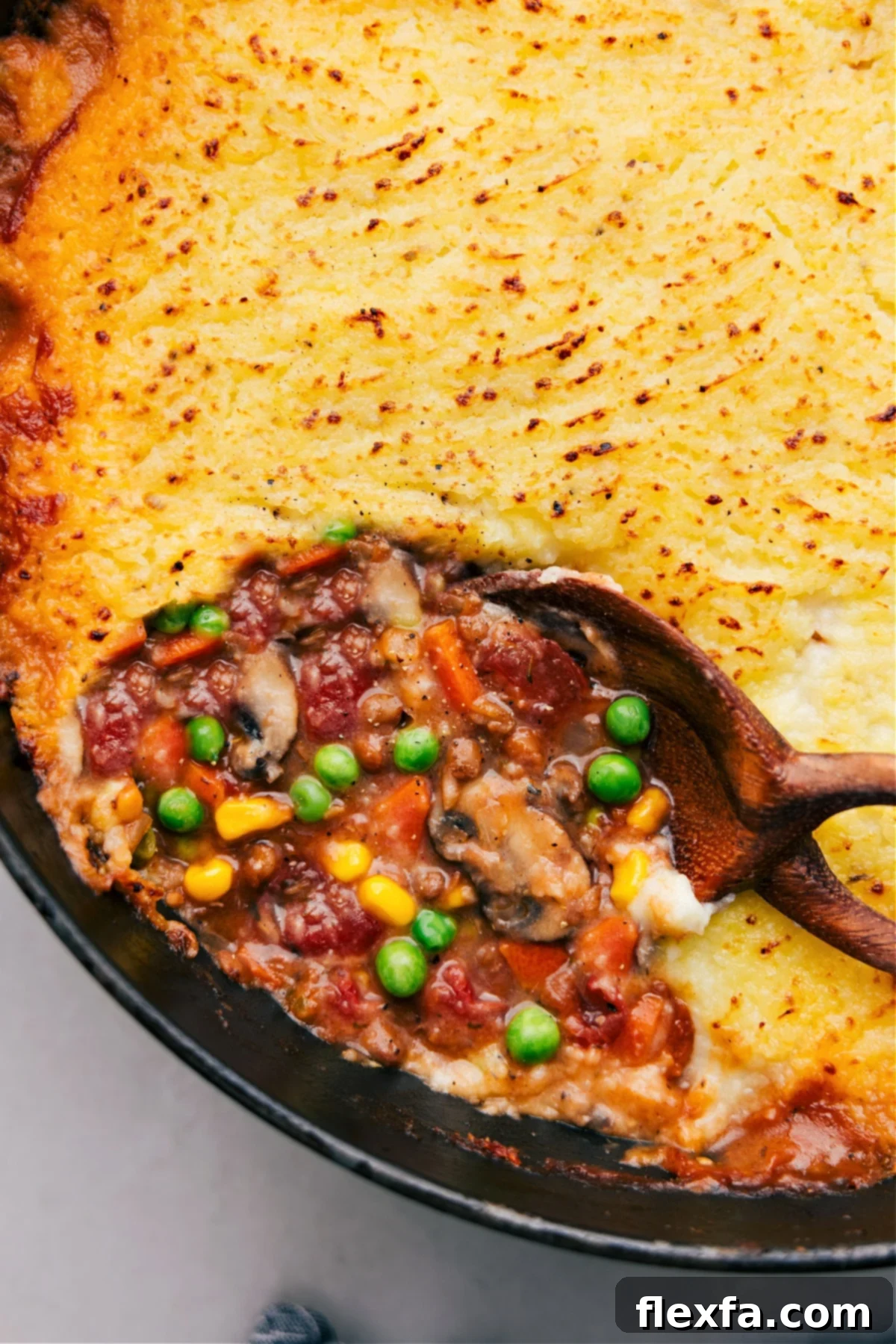 Delicious golden-brown Vegetarian Shepherd's Pie, fresh out of the oven, topped with perfectly textured mashed potatoes.