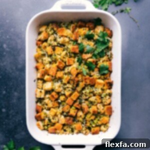 Golden cornbread dressing, garnished with fresh herbs, ready for serving.