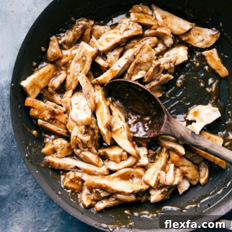 Cooked meat covered in a vibrant apricot sauce, simmering gently in a saucepan, ready to be served.