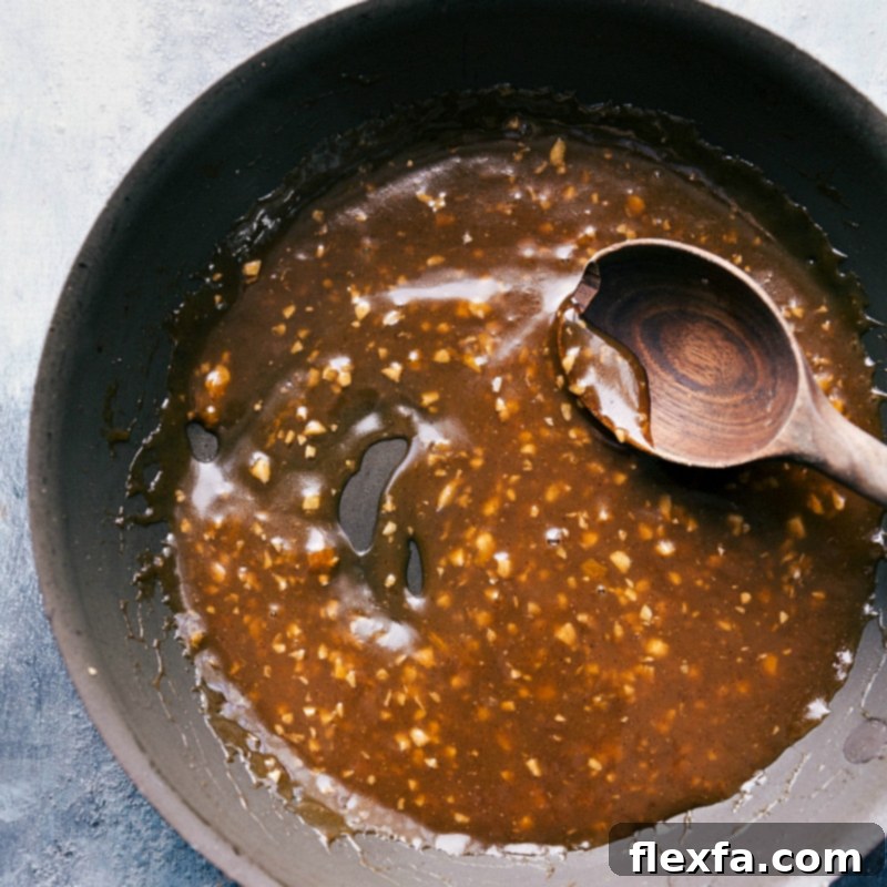 Preparing the apricot glaze sauce in a pan, showcasing the sweet and fruity reduction as it thickens, ready to coat the chicken.