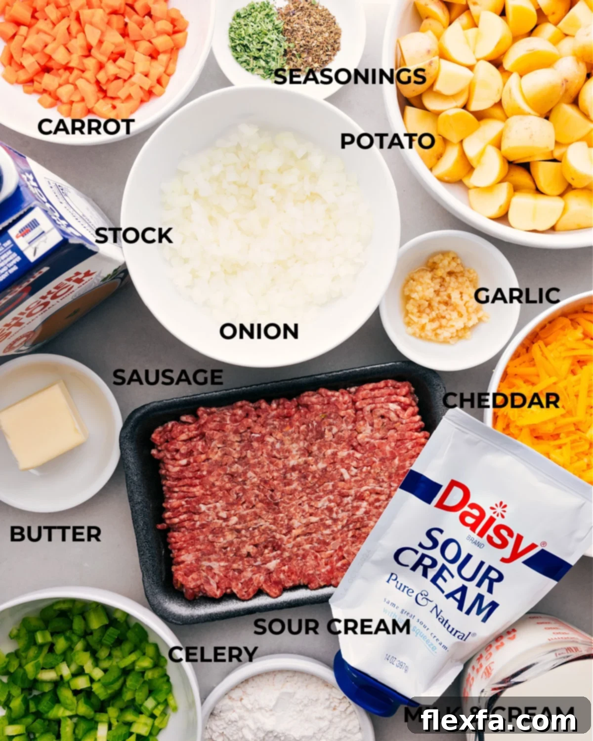 All the fresh ingredients for this savory Sausage Potato Soup, including neatly prepped potatoes, a colorful mix of mirepoix, Italian sausage, various seasonings, chicken stock, dairy products like butter and sour cream, laid out on a rustic wooden table, ready for assembly.