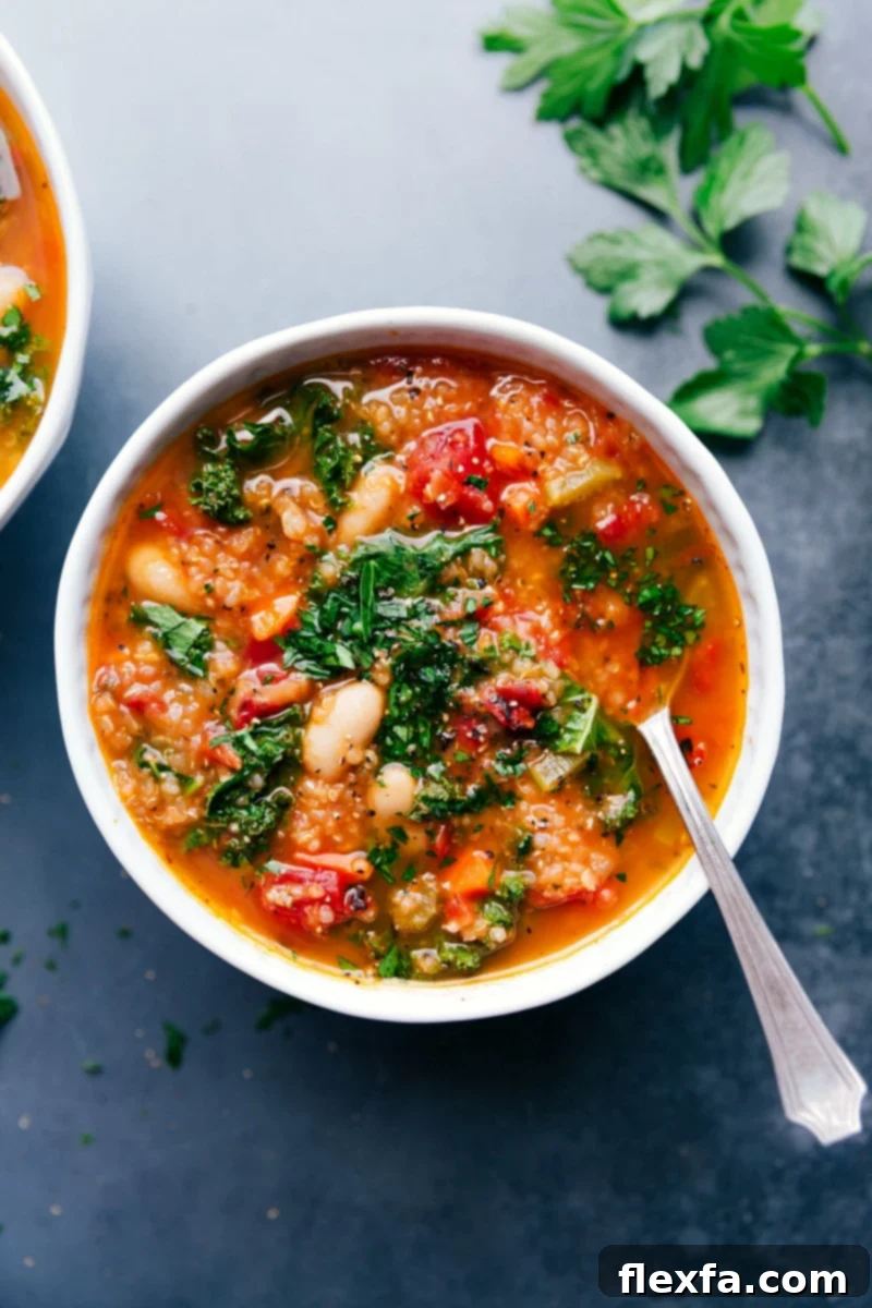 This one-pot white bean and kale soup is loaded with nutritious ingredients. This vegetarian soup is hearty and packed with plant-based protein (quinoa & white beans), but you can add in some shredded, cooked chicken if desired. Recipe via chelseasmessyapron #vegan #vegetarian #tuscan #easy #best #healthy #stove #quick #whitebean #kale #soup Overhead image of the white bean and kale soup with a spoon in it