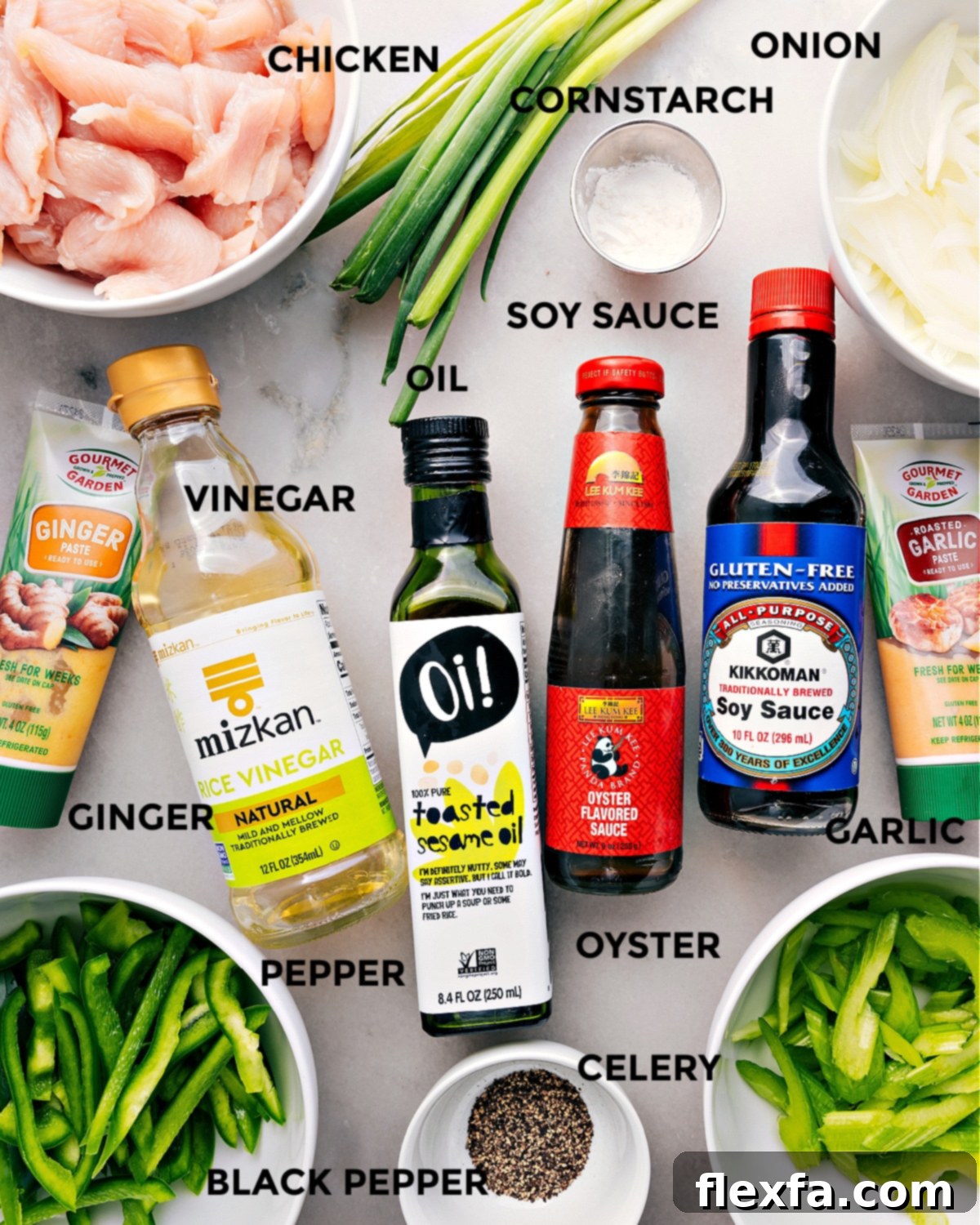 All ingredients for Black Pepper Chicken laid out: chicken breast, cornstarch, soy sauce, oyster sauce, sesame oil, green bell pepper, celery, yellow onion, ginger paste, garlic paste, rice vinegar, water, honey, black pepper, green onions, and cooked white rice.