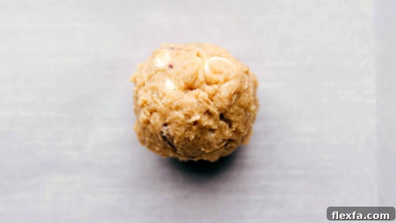 Process shot: Oatmeal Cranberry Cookies being rolled into balls, ready for baking.