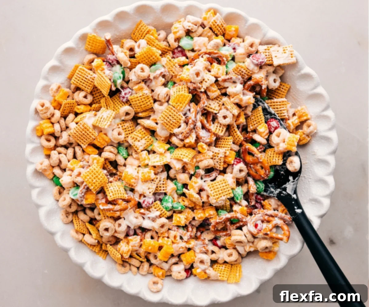 A large bowl filled with delicious Christmas Snack Mix, coated in white chocolate and ready to be served.