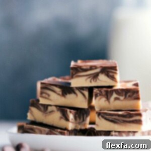Stacked slices of tiger butter fudge with distinctive chocolate and peanut butter swirls, ready to be enjoyed.