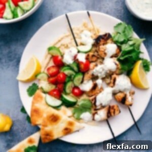 Shish tawook skewers served atop creamy hummus, ready to eat.