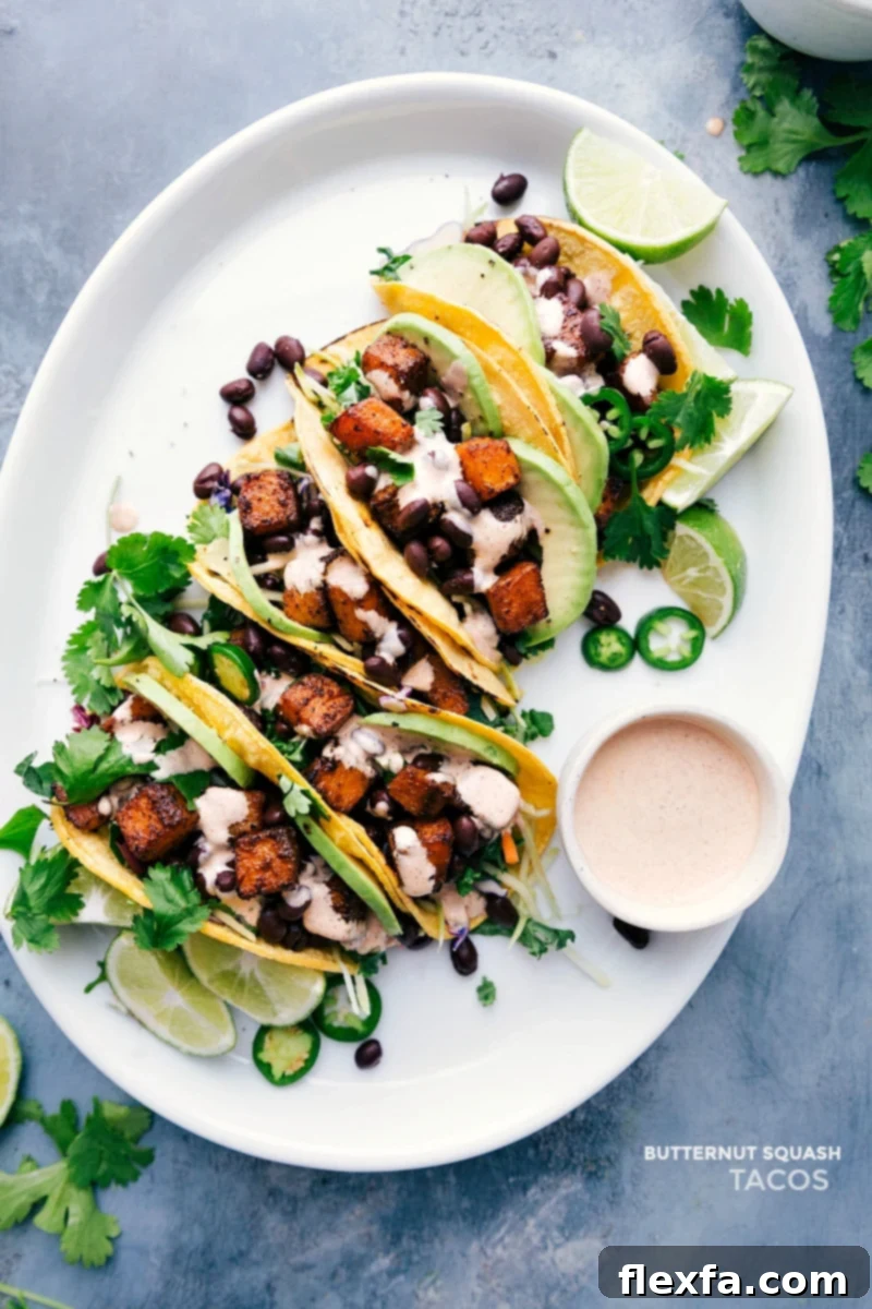 Delicious vegetarian Butternut Squash Tacos with roasted squash, black beans, and creamy sauce. A healthy and flavorful recipe for any occasion. Overhead view of vibrant Butternut Squash Tacos on a serving tray, garnished with fresh cilantro and lime, ready to be enjoyed.