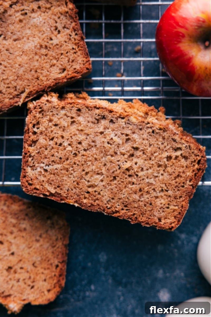 Overhead image of a beautifully baked apple bread loaf, golden brown and garnished, ready to be sliced.