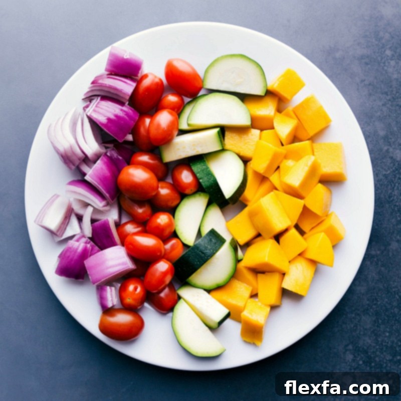Fresh and Vibrant Ingredients for Grilling Bright, vibrant, fresh fruit and vegetables on a plate, including mango, red onion, zucchini, and cherry tomatoes, before being grilled.