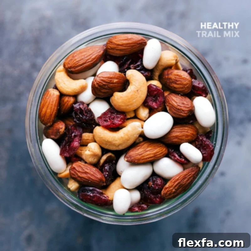 Completed healthy snack, a blend of nuts, seeds, and dried fruits, ready for snacking in a glass jar.