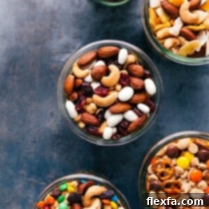 A top-down view of a clear glass jar filled with a delicious trail mix, featuring a mix of nuts, dried fruits, and other savory and sweet morsels, ready for snacking.