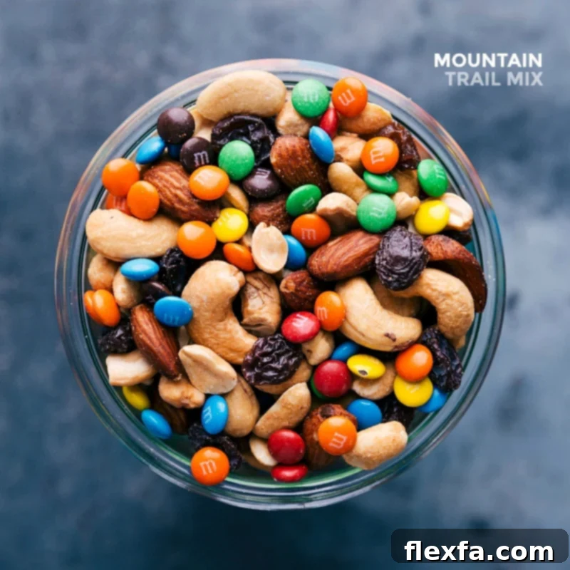 Glass jar filled with finished snack, showcasing an array of complementing flavors from various ingredients, including peanuts, M&M's, and nuts.