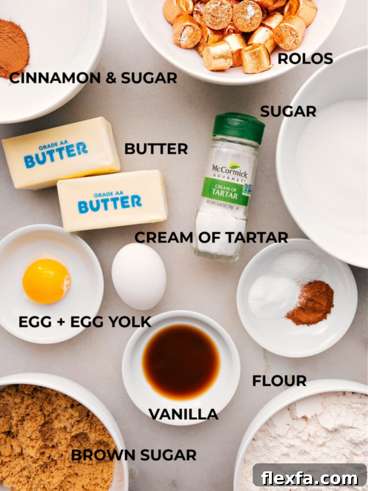 A beautifully arranged assortment of essential baking ingredients, including fresh butter sticks, aromatic cinnamon and granulated sugar, all-purpose flour, and other key components, laid out for making caramel snickerdoodles.