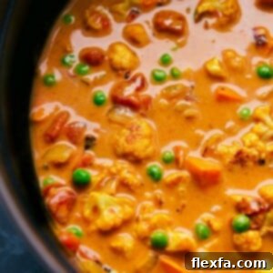 A hearty pot of vegetable curry brimming with colorful vegetables and simmered in a coconut curry broth.