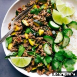 Beef larb accompanied by rice, with lime and cilantro garnishes.