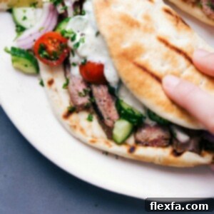 Steak gyros fully stuffed with succulent meat, fresh vegetables, and a delicious sauce, ready to be eaten.