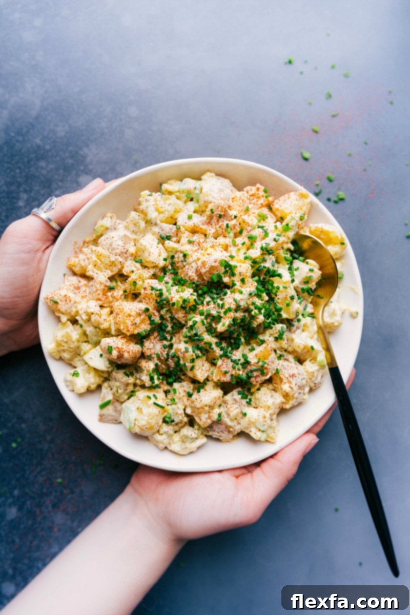 A large, beautifully garnished bowl of creamy potato salad, ready to be enjoyed as a perfect side dish.