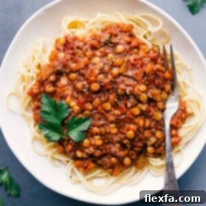 Lentil bolognese served over spaghetti, presenting a savory and mouth-watering meal.
