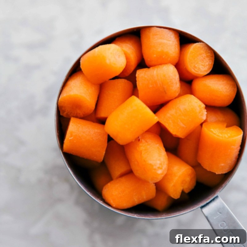 Freshly chopped carrots in a measuring cup, ready to be added to the One-Skillet Lemon Chicken and Potatoes.