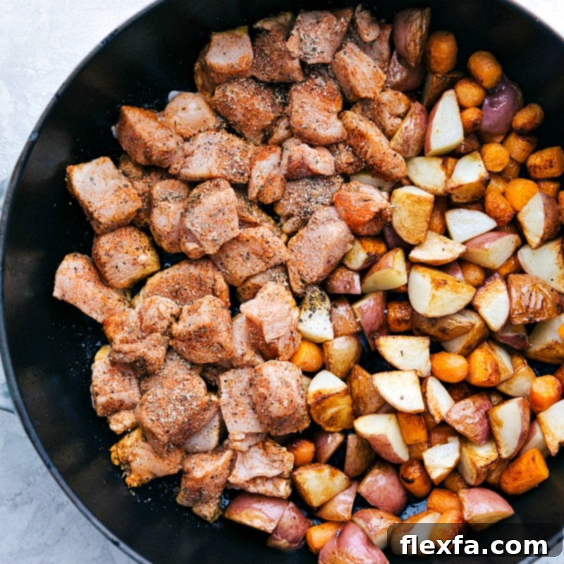 Perfectly cooked lemon chicken, potatoes, and carrots glistening in a skillet, ready to be served.