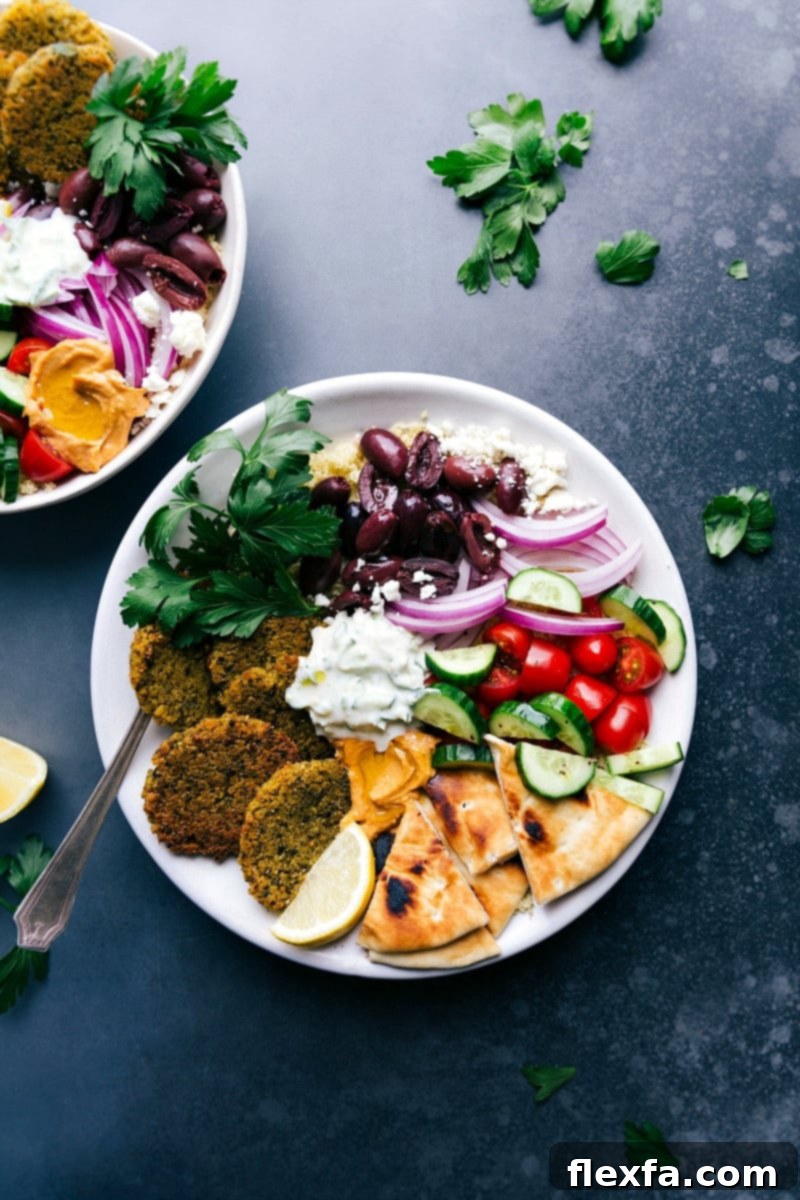 Baked falafel served on a plate with pita bread, tzatziki sauce, olives, onions, tomatoes, and cucumbers.