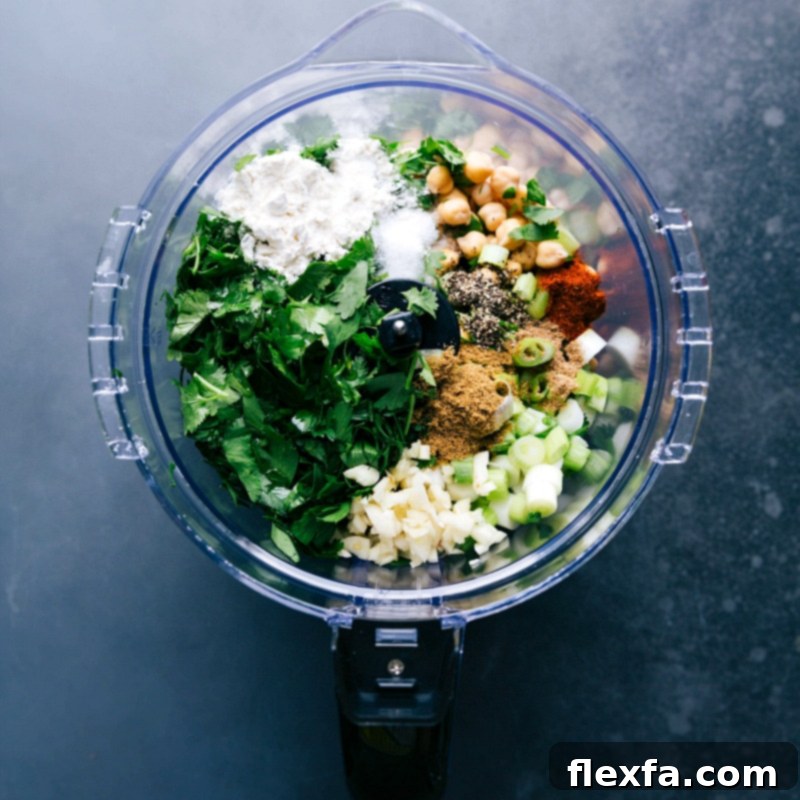 Making falafel by adding all ingredients into a food processor as part of the falafel recipe preparation.