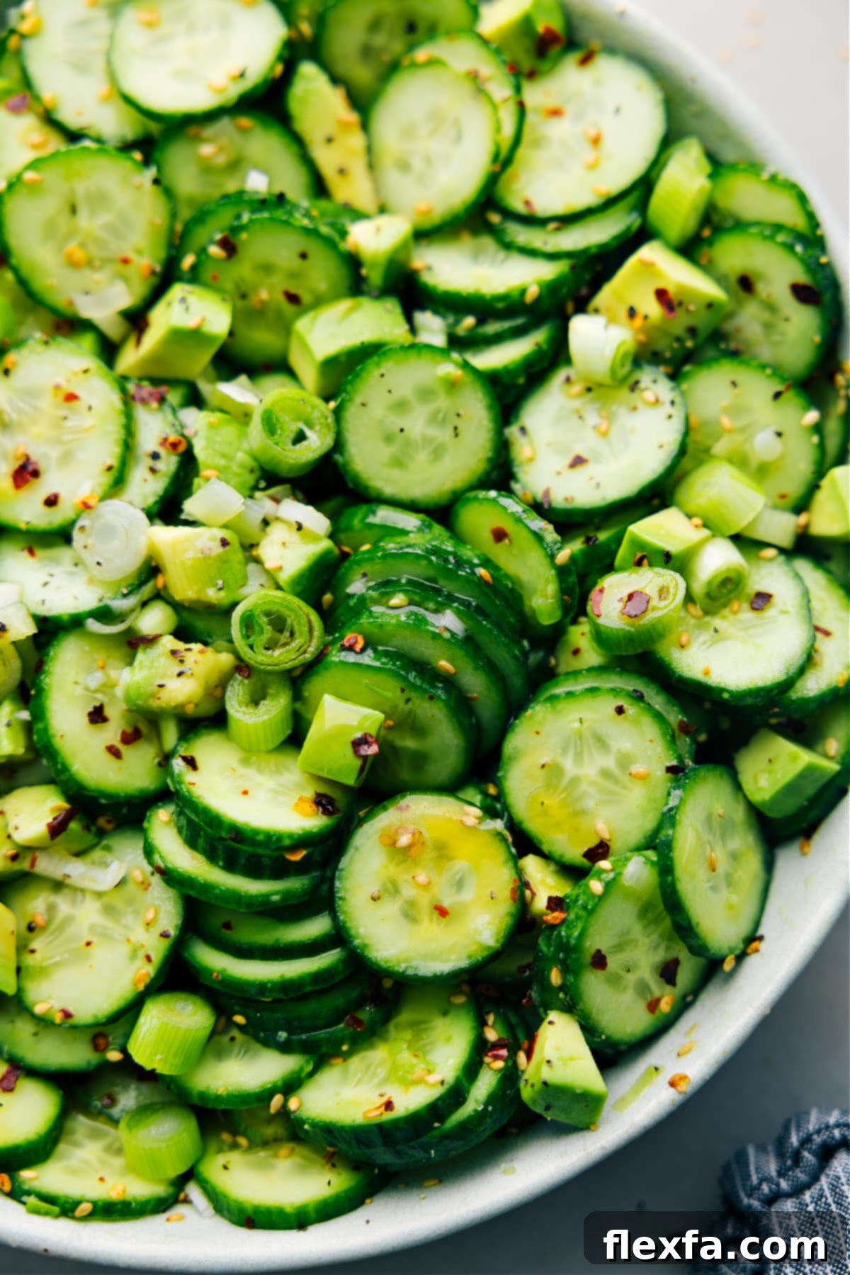 A large bowl of Asian Cucumber Salad, perfectly dressed and tossed, showcasing its vibrant colors and freshness.