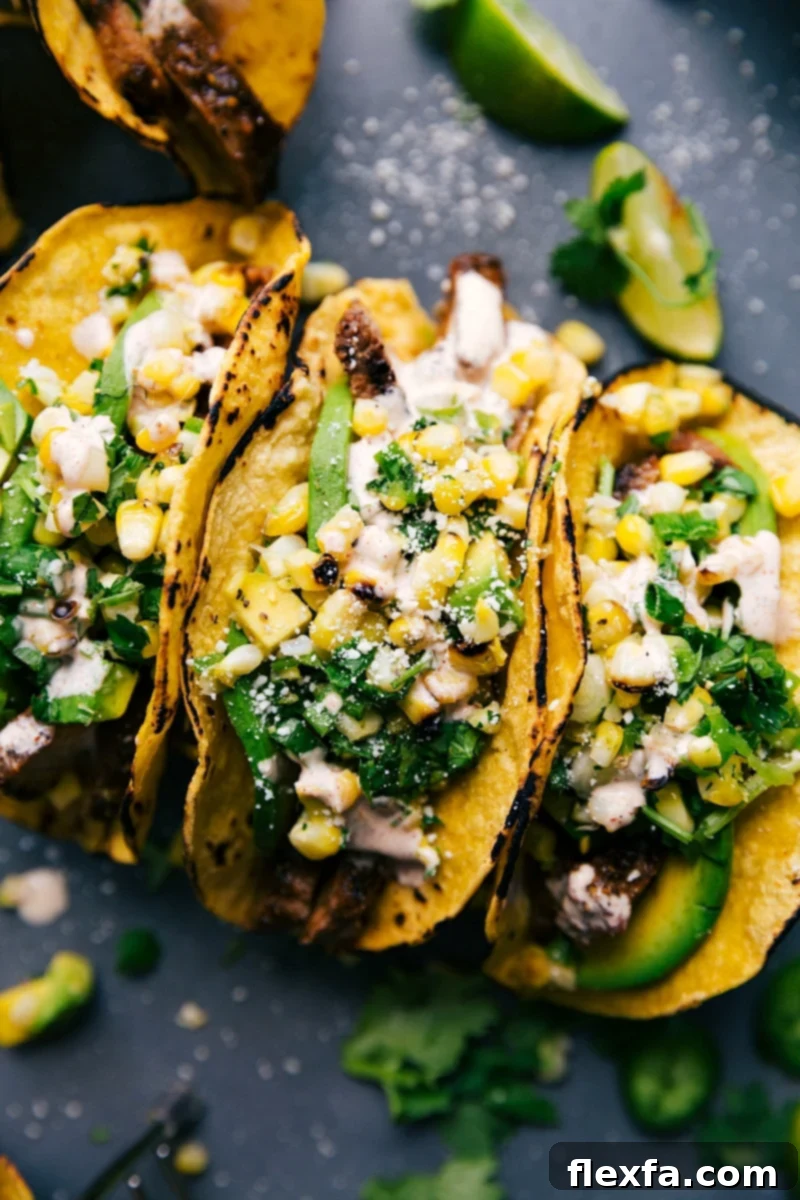 The finished steak tacos, beautifully arranged side by side on a plate, generously stuffed with perfectly cooked, tender steak, vibrant corn salsa, and a variety of fresh, colorful toppings, showcasing their irresistible appeal.