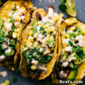 Finished steak taco recipe, with tacos side by side, stuffed with delicious meat, corn salsa, and various toppings.