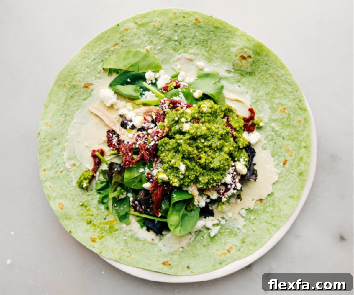 All the ingredients in these Mediterranean Wraps assembled inside a tortilla, ready to be rolled.