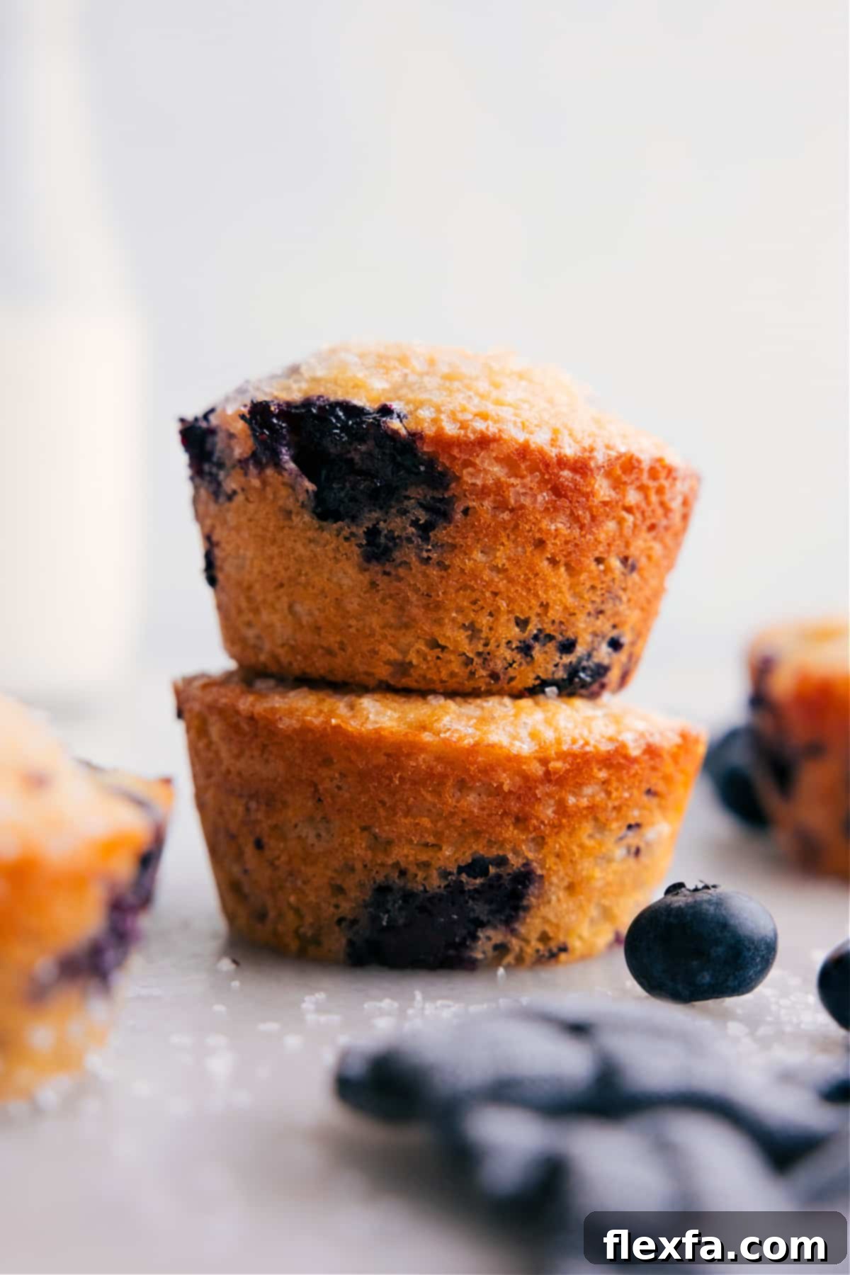 A stack of perfectly baked, healthy blueberry muffins, showcasing their golden tops and tender texture, ready to be enjoyed as a wholesome and delicious treat.