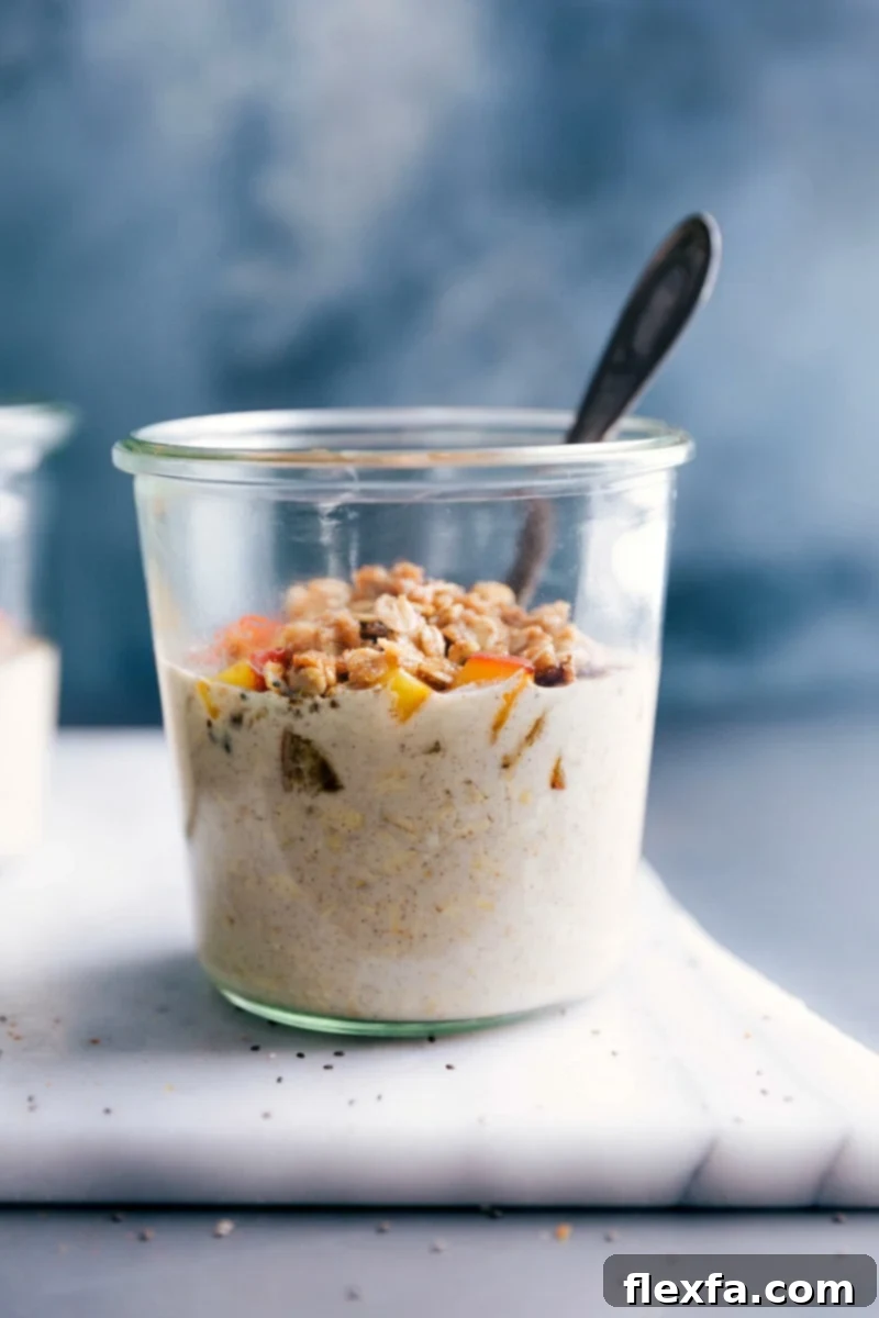 A beautifully presented bowl of Peach Cobbler Overnight Oats, adorned with fresh peach slices and crunchy streusel, ready to be enjoyed.